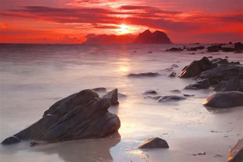 the sun is setting over some rocks in the water and it looks like they ...