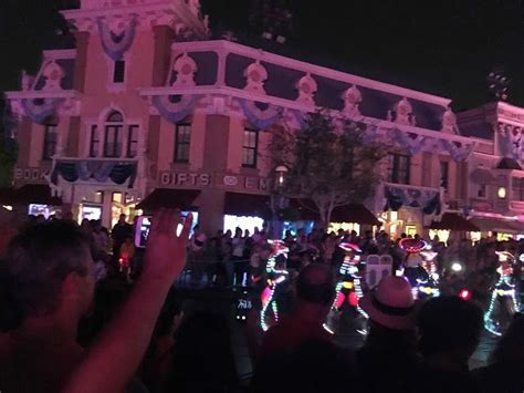 a crowd of people standing in front of a building with christmas lights on the ground