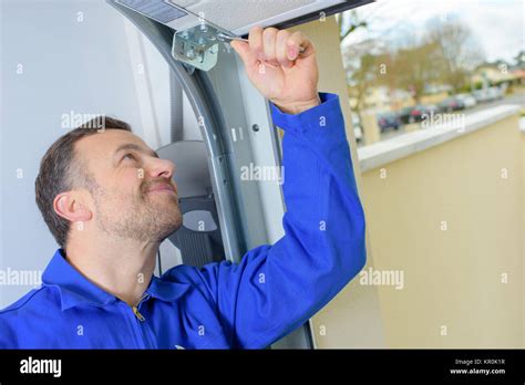 Man installing a garage door Stock Photo - Alamy