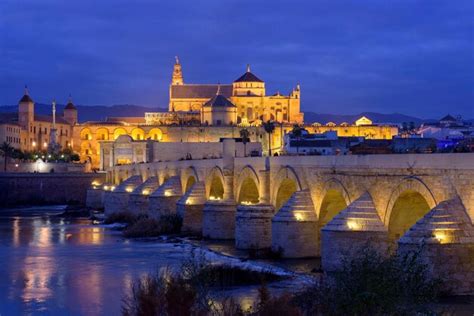 Premium Photo | Arch bridge over river at night