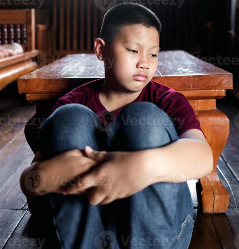 Portrait of a little Asian boy, Kid sad face, Unhappy child sitting hug knees on the floor ...