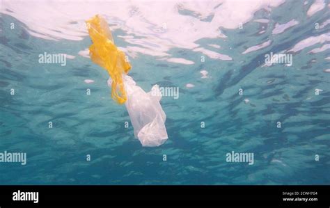 Plastic bag in blue ocean water. Plastic pollution in ocean environmental problem. Ecological ...