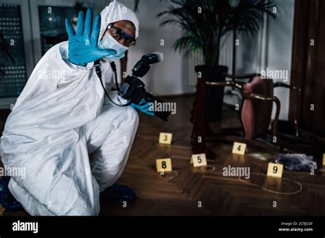 Crime scene. Forensics expert photographing evidence at a crime scene ...