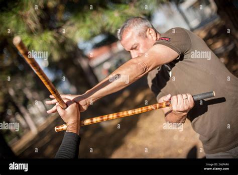 Escrima and kapap instructor demonstrates sticks fighting techniques and training methods in ...