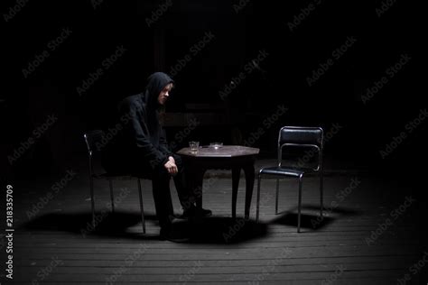 Dangerous man sitting alone in the dark Stock Photo | Adobe Stock