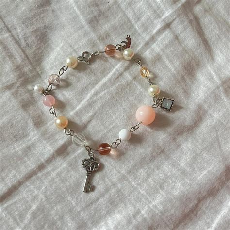 silver charm bracelet with pink and white pearl... - Depop