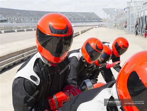 Pit crew wearing helmets in sunny pit lane — sports, fuel - Stock Photo | #202443946