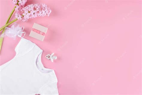 Download A White Baby Bodysuit On Pink Background With Flowers Wallpaper | Wallpapers.com