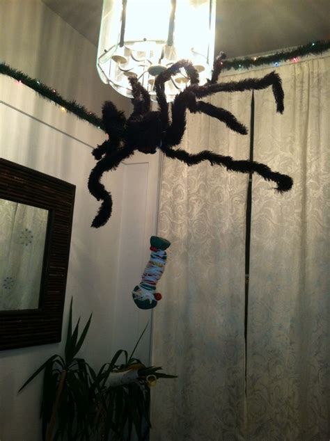 a spider is hanging from the ceiling in front of a curtain with lights ...