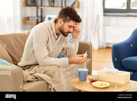 sick man measuring temperature by thermometer Stock Photo - Alamy