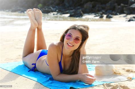 Portrait Of Young Woman Lying Down On Beach High-Res Stock Photo - Getty Images