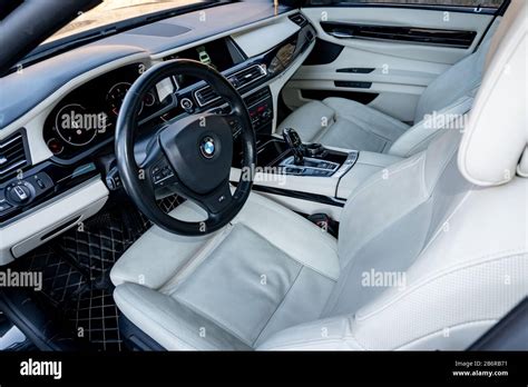 White leather interior seats and dashboard inside a luxurious BMW 750d black limousine with ...