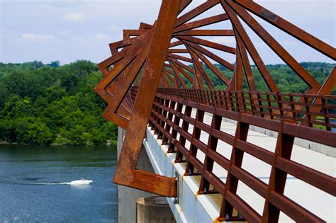 there is a boat going across the water on this bridge over looking the river and trees