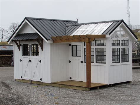 a small white shed with a metal roof