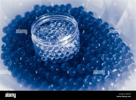 Pot of transparent balls on blue water gel balls with bokeh. Polymer gel Silica gel. Blue ...