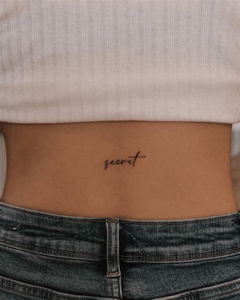 Tattoo of the word "secret" located on the lower back.