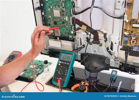 The Consumer Electronics Repair Engineer Measures the Voltage Stock ...