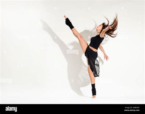 Agile fit young woman doing an ice skater dynamic developpe pose ...