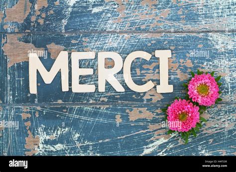 Merci (thank you in French) written with wooden letters and pink daisies Stock Photo - Alamy