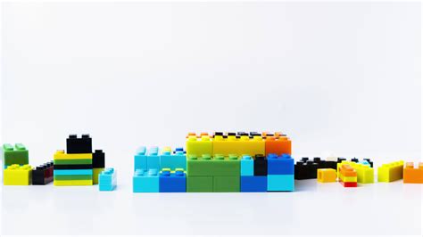 Stop motion animation of Lego houses are built with different colored blocks on white background ...