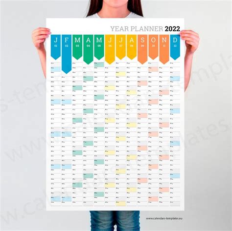 a woman holding up a poster with the year planner