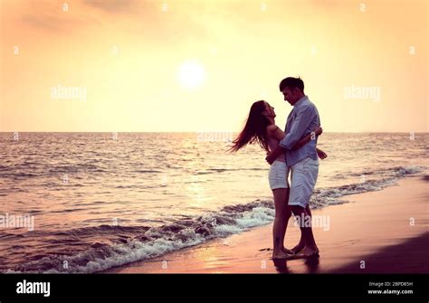 Romantic young Couple hug on the beach at sunset Stock Photo - Alamy