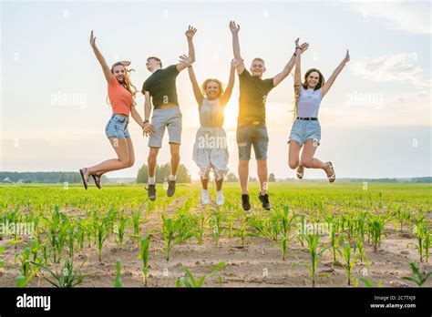 Friends are jumping holding hands at sunset Stock Photo - Alamy