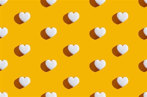 Premium Photo | Heart pattern yellow seamless background white