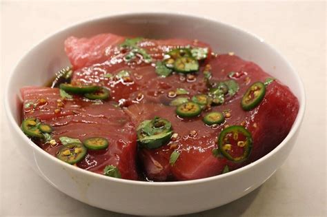 a white bowl filled with sliced up meat and veggies on top of it