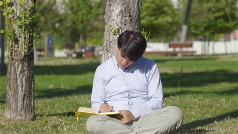 Young man writing diary outdoors. 33545805 Stock Video at Vecteezy