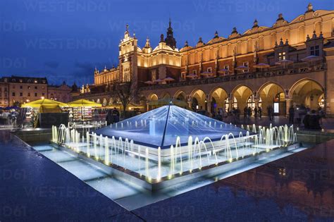 Poland, Krakow, Main Square in Old Town at night, illuminated fountain and Cloth Hall stock photo