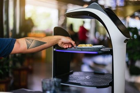 Premium Photo | Robot waiter serving food in a restaurant taking food from a waiter robot