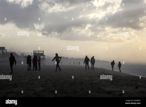 Palestinians enjoy at Gaza beach on a rainy day during sunset, on January 29, 2021, in Gaza ...