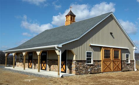 Custom barn with stone wainscotting, an overhang, custom entry doors and dutch doors, and a ...