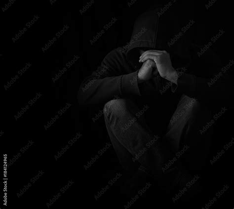 Young man sitting alone in dark room with depressed and anxiety ...