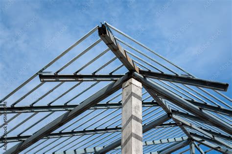 Iron beam roof structure of the house building, on blue sky background ...