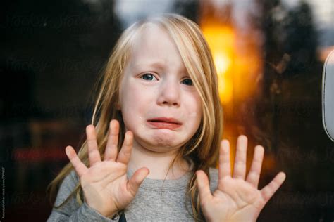 "Portrait Through Glass Of A Little Girl With A Sad Face" by Stocksy Contributor "Amanda Voelker ...