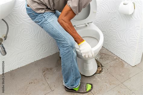 workerman performs repair of toilet bowl, To repair the pipe from the toilet Stock Photo | Adobe ...