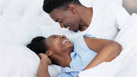 Happy Black Couple in Bedroom Kiss and Smile for Love, Romance and Intimacy at House or Home in ...