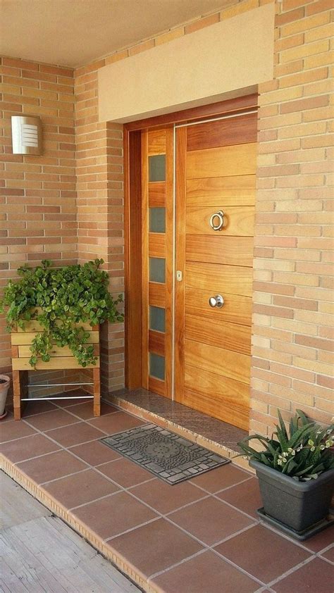 the front door is made of wood and has two planters on either side