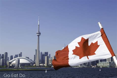 A Canadian maple leaf flag flutters on a sunny day in Toronto, Ontario | Go Eat Do