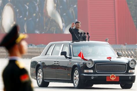 Chinese President Xi Jinping waves from a vehicle as he reviews the troops at a military parade ...