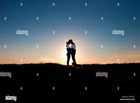 Romantic couple hug at sunset on background Stock Photo - Alamy