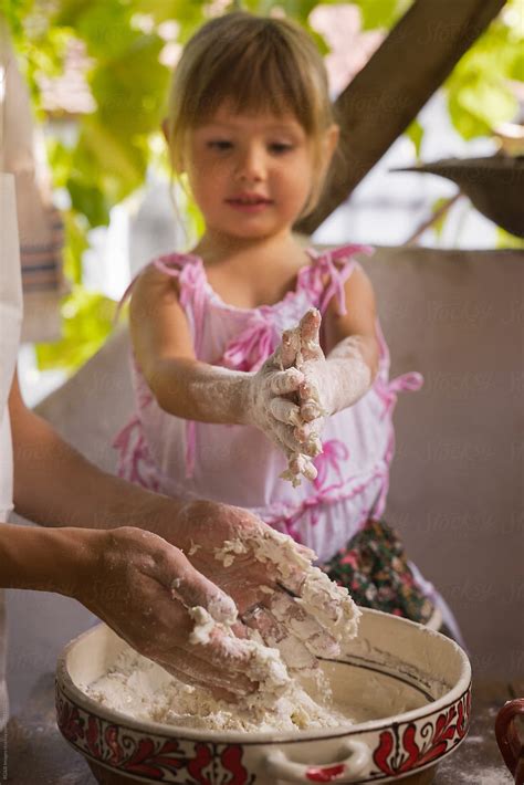 «Little Girl And Mother Kneading Bread Dough By Hand» del colaborador de Stocksy «Ibex.media ...