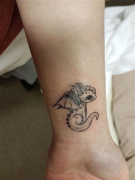 a small dragon tattoo on the ankle