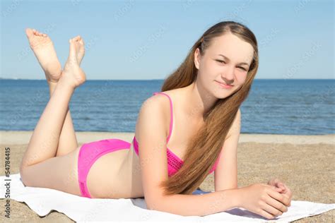 teenager in pink bikini lying on the beach Stock Photo | Adobe Stock