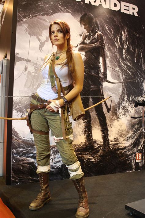 a woman dressed in costume is standing next to a poster with an arrow on it