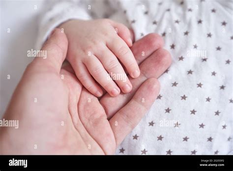 Mothers hand holding baby hand. The baby is one month old. Cute little hand with small fingers ...