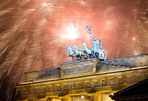 Fireworks explode next to the Quadriga sculpture atop the Brandenburg gate during New Year ...