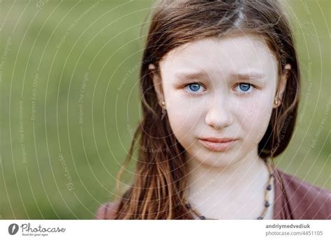 Portrait of sad crying emotional cute little girl looking at camera with face of deep sadness ...